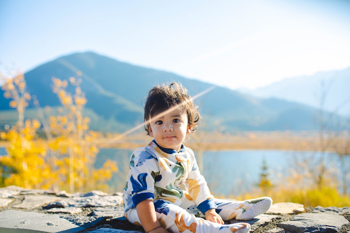 Child sitting beside a lake in autumn