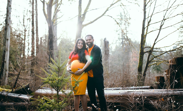 Expectant couple embracing in the woods