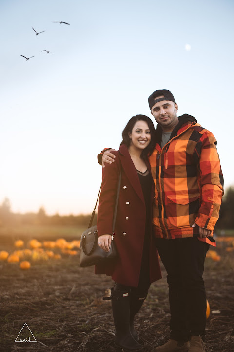 Couple beneath an evening sky at a pumpkin patch