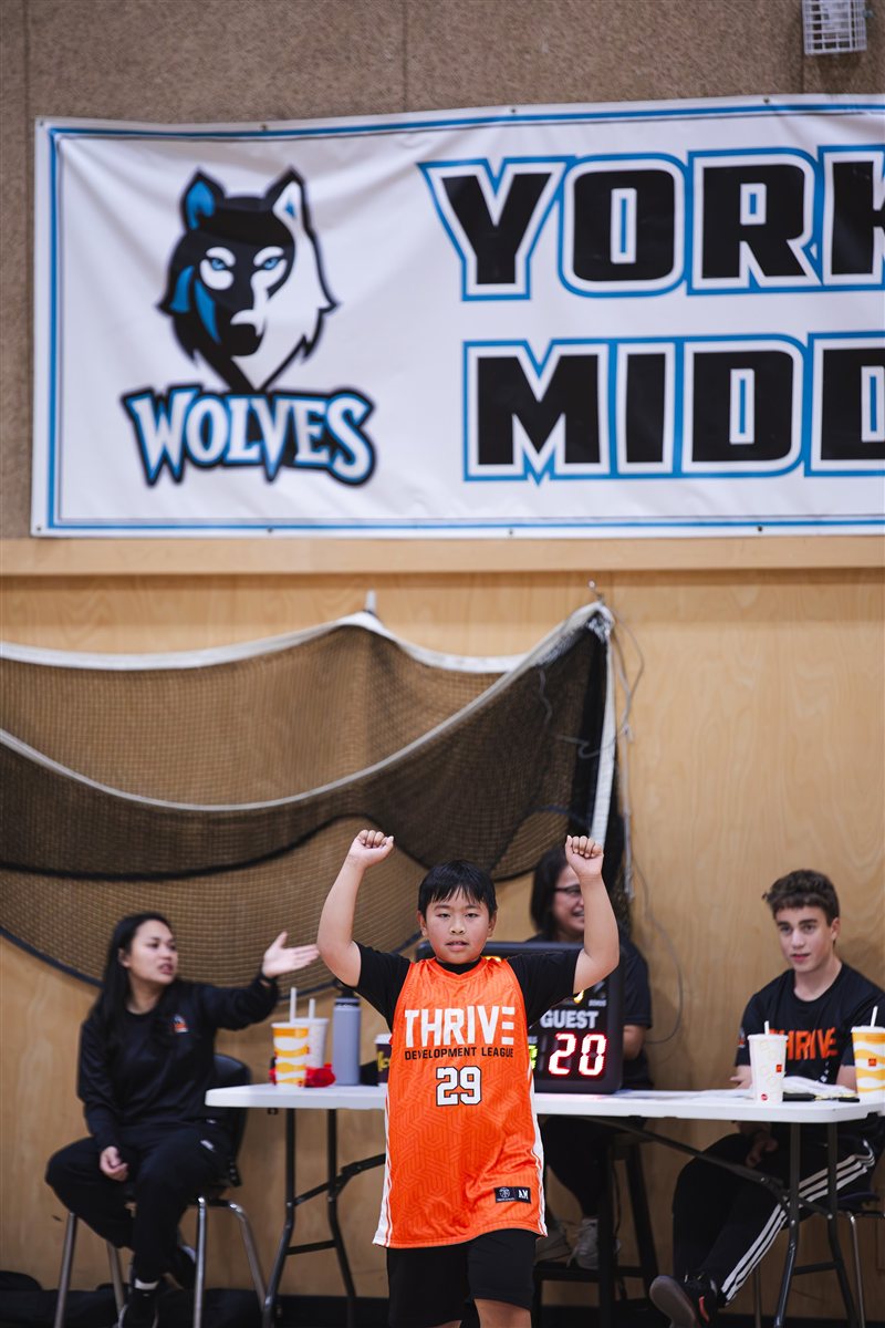 Basketball player releasing a shot in a school gym