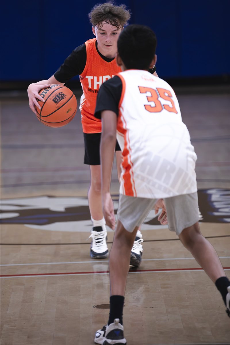 Basketball player dribbling in front of a defender