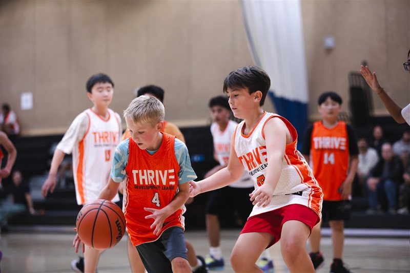 Basketball player driving between defenders
