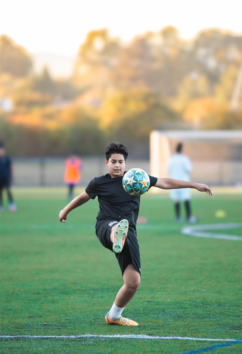 Soccer player moving toward an airborne ball