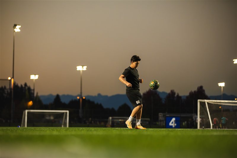 Soccer player moving across the field at dusk