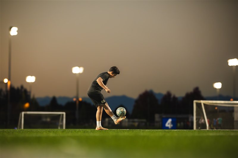 Soccer player preparing a kick under floodlights