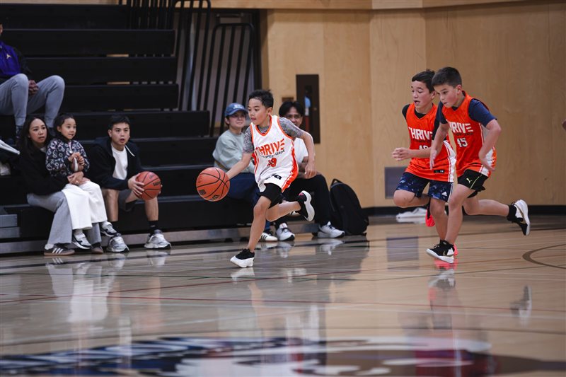 Basketball players sprinting down the court